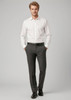 A man stands wearing a white shirt and grey classic flat pants, paired with a belt and black shoes. The outfit includes branding.