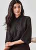 A black 3/4 sleeve blouse with a collar and button-up front, featuring a subtle branding logo. A black 3/4 sleeve blouse with a collar and button-up front, featuring a subtle branding logo.