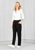 A woman stands wearing black straight leg pants and a white blouse, smiling. The pants have pockets and a logo. A woman stands wearing black straight leg pants and a white blouse, smiling. The pants have pockets and a logo.