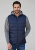 A man wearing a navy blue quilted alpine vest over a grey hoodie, with a casual expression.