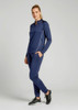 A woman wearing a navy blue unisex mid-layer top with long sleeves and matching pants, standing against a plain background.