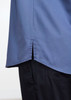 A blue short sleeve chef shirt with a split hem, paired with dark trousers, featuring a logo.