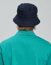 A navy bucket hat with a contrasting underbrim, shown from the back, paired with a teal shirt.