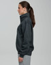 A grey 1/2 zip collar fleecy jumper displayed on a model from the side, featuring a smooth fabric and a logo.
