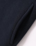 A close-up of a navy fleecy jumper featuring a half-zip collar and pockets. The fabric appears soft and textured.