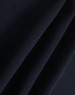 A close-up of dark navy polar fleece fabric showing soft, smooth texture folds. It features a branding logo.