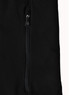 A close-up of a black softshell jacket featuring a zipped pocket and a branded logo.