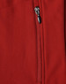 A close-up of a red softshell vest featuring a zippered pocket and a logo.
