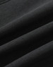 A close-up of a black softshell fabric with a smooth texture, featuring folds and creases.