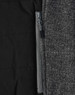 A grey heather fabric with a quilted black interior and a zippered pocket detail. The jacket has a sleek design.