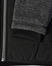 A black quilted jacket featuring heather grey sleeves and a ribbed cuff, with a side zipper and fabric texture detail.