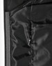A close-up of a quilted jacket's interior lining in black, featuring a zippered pocket and smooth texture.