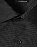 A close-up of a black pin dot stretch button-up shirt, featuring a collar and a single button.