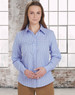 A woman models a blue and white gingham check button-up shirt with long sleeves in a bright indoor setting.