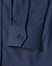 A navy blue pin dot stretch long sleeve shirt with a buttoned cuff and a branded logo.