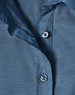 A close-up of a blue pin dot stretch 3/4 sleeve shirt featuring buttons and a fabric texture.
