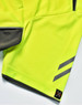 A close-up of a bright yellow polo shirt featuring grey accents and a logo on the hem.