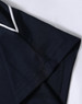 A close-up of a navy blue polo shirt featuring a white trim on the collar and sleeve.