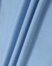 A close-up of light blue fabric, showcasing the texture and folds of a polo shirt material.