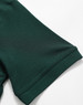 A close-up of a dark green polo shirt sleeve featuring a logo. The fabric appears smooth and lightweight.