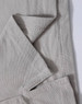 A close-up of a light grey polo shirt, showing the textured fabric and stitching details. The shirt features a logo.
