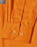 An orange work shirt featuring cuff details and a textured panel, with a logo visible on the fabric.
