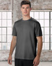 A men's short sleeve tee in grey, featuring a minimal design and a logo. The model stands against a large window background.