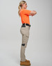 Work pants in beige with black accents, styled on a model wearing an orange top, showcasing a side view.