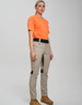 Work pants in beige with black accents, worn by a model in an orange shirt and brown boots, standing against a neutral background.