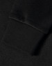 A close-up of a black jacquard fleece jacket's textured fabric and cuff. Features a logo.
