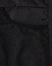 A close-up of the interior of a black insulated puffer jacket, featuring mesh pockets.