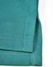 A close-up of a teal men's sustainable poly/cotton polo shirt, featuring a detailed hem and stitching.