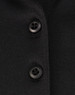 A close-up of a black polo shirt featuring buttons and a subtle texture, highlighting its sustainable fabric.