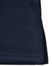 A navy polo shirt featuring a side vent detail and a logo on the fabric.
