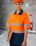 A safety polo shirt in high-visibility orange with reflective stripes and a navy blue lower section, worn by a model.