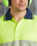A close-up of a unisex, long-sleeve, high-visibility polo shirt in vibrant yellow with a navy collar and a pocket.
