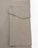 A close-up of a beige work pant pocket featuring a flap, showcasing the fabric texture and stitching detail.