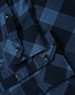 A blue and navy plaid flannel shirt with button-up detailing and a pocket. It features metal snap buttons.