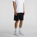 Black sports shorts with a drawstring, featuring a logo, worn with a white T-shirt and white sneakers. Black sports shorts with a drawstring, featuring a logo, worn with a white T-shirt and white sneakers.