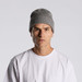 A grey knit beanie being worn by a model in a plain white T-shirt against a neutral background. A grey knit beanie being worn by a model in a plain white T-shirt against a neutral background.