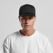 A black Frame Foam Trucker Cap with a structured front and a logo, worn by a model in a white t-shirt. A black Frame Foam Trucker Cap with a structured front and a logo, worn by a model in a white t-shirt.
