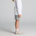 Kids stadium shorts in light grey, paired with a long-sleeve white top and patterned sneakers. Kids stadium shorts in light grey, paired with a long-sleeve white top and patterned sneakers.