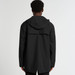 A black rain jacket featuring a hood and a back vent, with a branding logo on the garment. A black rain jacket featuring a hood and a back vent, with a branding logo on the garment.