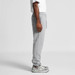 Grey track pants with an elastic waistband, side pockets, and a relaxed fit, paired with a white t-shirt and sneakers. Grey track pants with an elastic waistband, side pockets, and a relaxed fit, paired with a white t-shirt and sneakers.