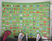 A curved media wall featuring a vibrant green background with numerous flags from various countries.