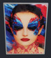 A slimline light box featuring an artistic portrait with vibrant blue and red butterfly makeup on a model. A slimline light box featuring an artistic portrait with vibrant blue and red butterfly makeup on a model.
