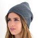 A grey beanie with a ribbed texture, worn by a model with long hair, featuring a logo on the side. A grey beanie with a ribbed texture, worn by a model with long hair, featuring a logo on the side.