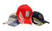 Three caps featuring peak and crown strike embroidery. Colours include red, navy, and grey, with various logos.