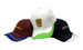 Three caps displayed: a maroon cap with blue and yellow accents, a white cap with green accents, and a black cap with a logo.