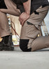 Men's work pants in beige with black accents, featuring cargo pockets and reinforced knee sections. Men's work pants in beige with black accents, featuring cargo pockets and reinforced knee sections.